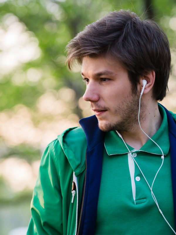 young-man-with-earphones-listening-to-music-portrait-of-person-in-the-park-who-is-thinking-about.jpg